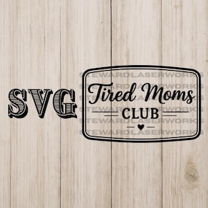 Puede incluir: Diseño SVG en blanco y negro con el texto "SVG" a la izquierda y "Tired Moms CLUB" dentro de un marco rectangular a la derecha, con un símbolo de corazón. Fondo de vetas de madera clara.