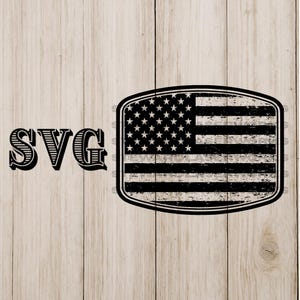 May include: Black and white distressed American flag design with the letters "SVG" on a light wood grain background. The flag is rectangular with a rounded border, featuring stars and stripes.