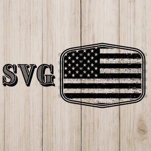 Könnte beinhalten: Schwarz-weißes Design der amerikanischen Flagge im Used-Look mit den Buchstaben "SVG" auf hellem Holzmaserungshintergrund. Die Flagge hat eine schildförmige Form mit Sternen und Streifen. Geeignet für digitale Designprojekte.