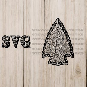Puede incluir: Gráfico SVG en blanco y negro de una punta de flecha con un diseño texturizado. La palabra "SVG" está impresa en una fuente decorativa en negrita. El fondo es una veta de madera marrón claro.