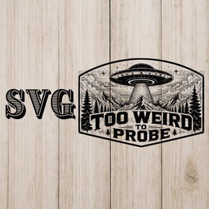 May include: Black and white graphic design featuring a UFO over a mountain range with the text "TOO WEIRD TO PROBE". The word "SVG" is on the left. The design is set against a light wood grain background.