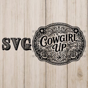 以下が含まれることがあります： 「SVG」の文字と「Cowgirl Up」の文字が入った装飾的な楕円形が特徴の、白黒のSVGデザイン。 楕円形は花柄と星柄で装飾され、明るい木目調の背景に配置されています。