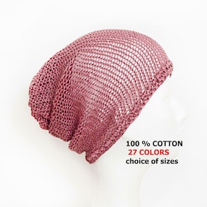 May include: A dusty rose beanie with an open-knit, mesh-like texture. The hat is displayed on a mannequin head. Text on the image reads: 100 % COTTON, 27 COLORS, choice of sizes. The beanie features a slouchy fit and a ribbed edge along the bottom.