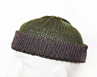 Könnte beinhalten: Eine Strickmütze mit einer dunkelolivgrünen Krone in strukturiertem Lochstrickmuster und einem einfarbigen, dunkelbraunen Rippstrickbündchen. Die Mütze hat eine abgerundete, eng anliegende Form und wird auf einem weißen Schaufensterkopf präsentiert.