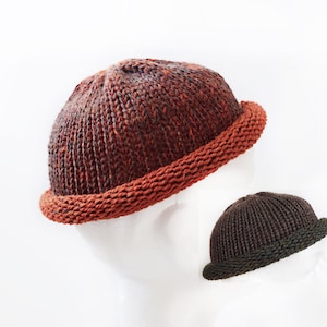 May include: Two knitted hats, one with a brown and orange color scheme and the other with a dark brown color scheme.