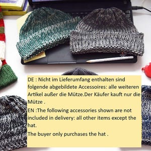 May include: Several knitted beanies in shades of gray, green, and blue are displayed. The hats have a textured appearance. A red and white scarf with pom-poms is also visible. The image includes text in German and English.