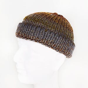 May include: A brown, gray, and yellow knit beanie with a fold-over brim.