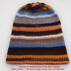 May include: A knit beanie featuring horizontal stripes in shades of brown, beige, orange, light blue, and dark blue. The text at the bottom reads: Example of finished beanie at the client's request. Client's wishes : "I like brown, beige, orange, blue rust, light blue".