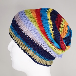 May include: A slouchy knit beanie featuring horizontal stripes in vibrant colors including navy blue, light purple, lime green, bright orange, and turquoise. The hat has a ribbed brim and a textured, multi-colored pattern throughout the fabric.