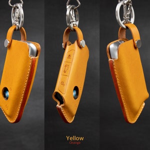 May include: Three leather keychains with a silver metal loop and a key fob holder. The keychains are in different colors: yellow, orange, and brown.
