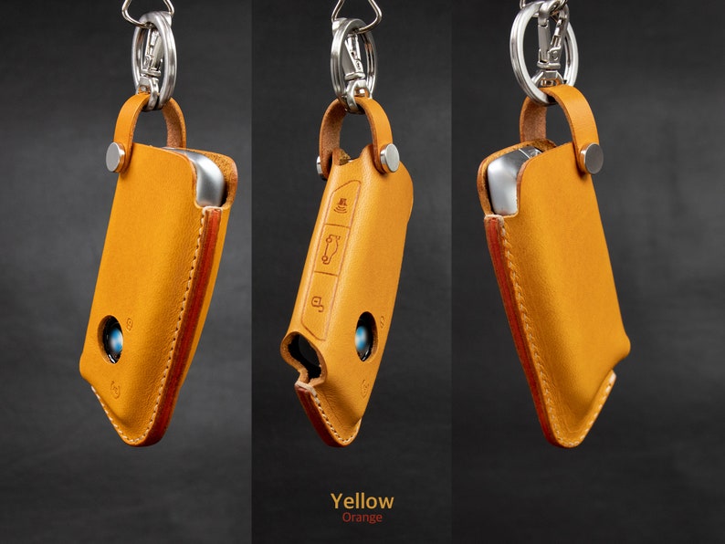 May include: Three leather keychains with a silver metal loop and a key fob holder. The keychains are in different colors: yellow, orange, and brown.