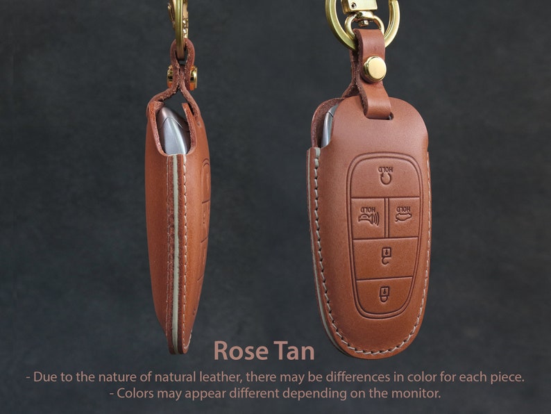 May include: A brown leather key fob with a key chain. The fob has four buttons with the word "HOLD" printed on them. The fob is labeled "Rose Tan".