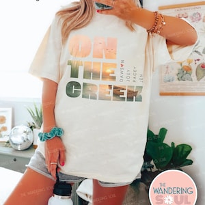 Retro Comfort Colors cream graphic tee featuring watercolor lake sunset and row boat, nostalgic millennial women vintage aesthetic shirt