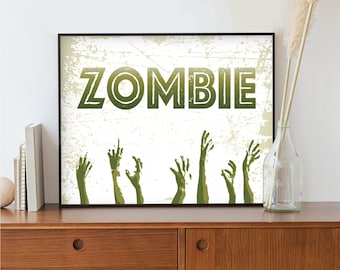 May include: A black framed print with a white background and green text that reads "ZOMBIE".  There are green zombie hands reaching up from the bottom of the print.