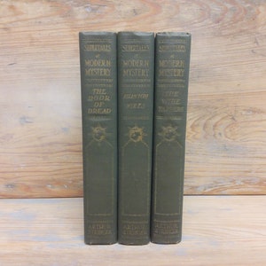 May include: Three vintage green hardcover books with gold lettering. The titles are "The Door of Dread", "Phantom Wires", and "The Three Taperers". All three books are part of the "Supertales of Modern Mystery" series by Arthur Stringer.