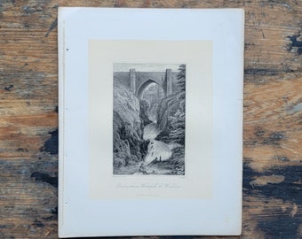 May include: A black and white engraving of a stone bridge over a rushing waterfall. The bridge has a pointed arch and is surrounded by trees. The text "Pont-y-Pair Waterfall, by Walker" is printed below the image.