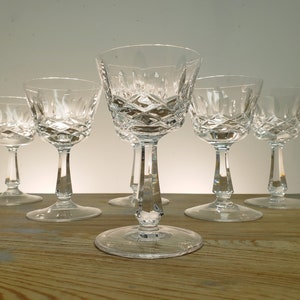 May include: Set of six clear crystal glasses with a diamond pattern. The glasses have a short stem and a wide bowl.