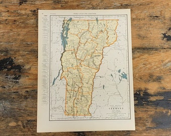 May include: A vintage map of Vermont, printed in black and white with orange and yellow highlights. The map shows the state's counties and major cities. The title "Rand McNally Popular Map of Vermont" is printed in the bottom right corner.