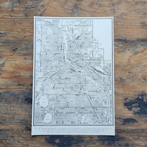 May include: A black and white map of Minneapolis, Minnesota. The map shows the city's streets, parks, and waterways. The text on the map reads: "Map of Central Minneapolis, The Largest City in Minnesota, The Great Water Power of the Falls of St. Anthony, and the Transportation Facilities of the City. Has Made Minneapolis the Most Important Manufacturing City in the Northwest. The Largest Wheat Market and Flour Producer of the Country."