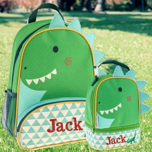 May include: Green dinosaur-themed backpack and lunch bag set with a geometric pattern and the name "Jack" embroidered on each piece.