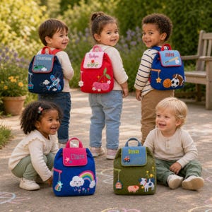 May include: Five quilted backpacks with personalized names and embroidered designs. The bags feature themes including an airplane, cherries, sports balls, a rainbow with a cloud, and farm animals. Each bag has a flap closure and a small hanging charm.