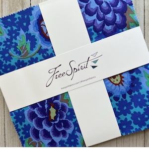 May include: A pack of fabric squares featuring a blue floral pattern with a white label that says "Free Spirit" and the website address "freespiritfabrics.com".