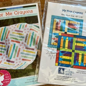 Może przedstawiać: Dwa wzory do patchworku, "Color Me Crayons" i "My First Crayons". Pierwszy wzór przedstawia kolorową kołdrę z wzorem kredki. Drugi wzór przedstawia kołdrę dla niemowląt z wzorem kredki. Oba wzory są oznaczone nazwą wzoru i rozmiarem kołdry.