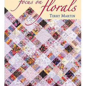 Puede incluir: Portada del libro "Focus on Florals" de Terry Martin. La portada presenta un diseño de colcha de retazos con varios patrones florales en tonos de rosa, morado, azul y verde. El texto "Quilts from Pretty Prints" está en la parte inferior.