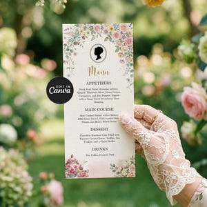 Puede incluir: Una tarjeta de menú decorativa con diseños florales y una silueta. El menú enumera aperitivos, platos principales, postres y bebidas. La tarjeta la sostiene una persona con guantes de encaje.