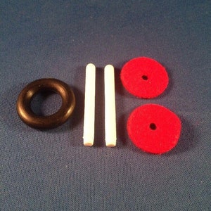 May include: A set of magic props including two white wands, a black rubber ring, and two red felt circles with a hole in the center.