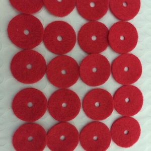 May include: Twenty red felt circles with a hole in the center. The circles are arranged in four rows of five.