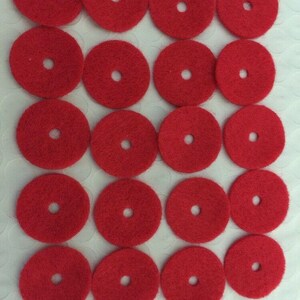 K&ouml;nnte beinhalten: Zwanzig rote Filz-Kreise mit einem Loch in der Mitte. Die Kreise sind in vier Reihen zu f&uuml;nf angeordnet.