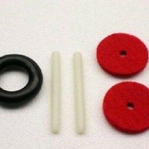 May include: Two red felt circles with a hole in the center, a black rubber ring, and two white plastic tubes.
