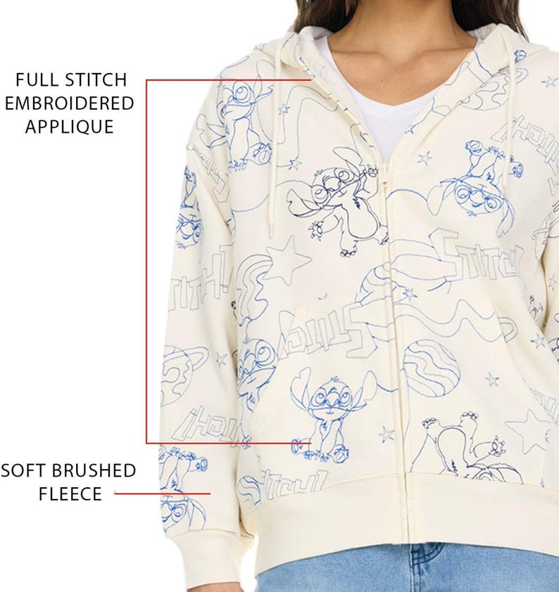 May include: Cream-colored zip-up hoodie with a blue embroidered Stitch design. The hoodie features a full stitch embroidered applique and soft brushed fleece. The design includes Stitch characters, stars, and text. The hoodie has a hood and a zipper closure.