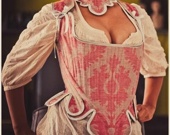 Op de afbeelding: Een roze en witte corset met een bloemenpatroon. Het corset heeft een gegolfde halslijn en een witte kantversiering.