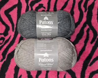 May include: Two skeins of Patons Classic Wool Worsted yarn in gray and light gray, each labeled 3.5 oz / 100 g. The yarn is displayed against a pink and black zebra-striped background, suitable for knitting and crochet projects.