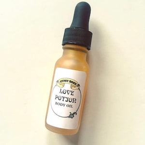 May include: A small glass bottle with a black dropper top and a white label that reads "Gypsy Rose Love Potion Body Oil".