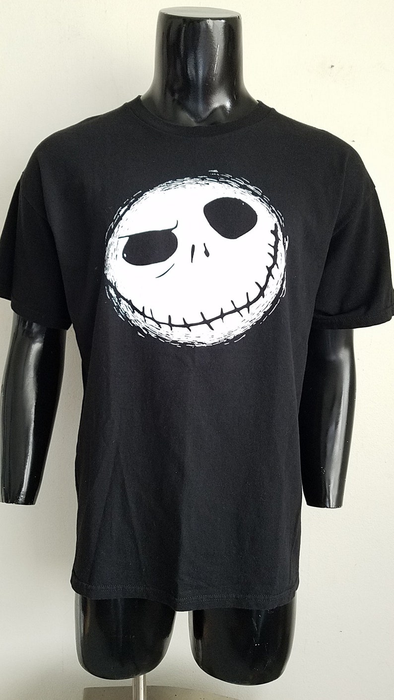 K&ouml;nnte beinhalten: Schwarzes T-Shirt mit einem wei&szlig;en Aufdruck von Jack Skellingtons Gesicht aus dem Film Nightmare Before Christmas.