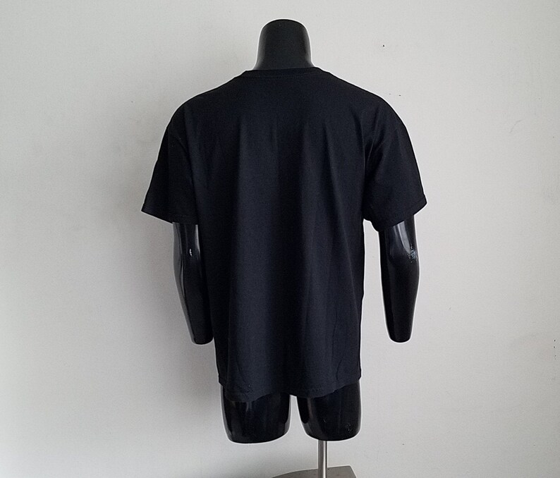 K&ouml;nnte beinhalten: Schwarzes T-Shirt mit kurzen &Auml;rmeln auf einer Puppe.