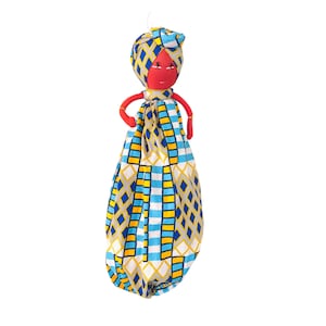 May include: A red fabric doll with a blue and yellow patterned dress and a head wrap. The doll has a simple face with black eyes and a red mouth.