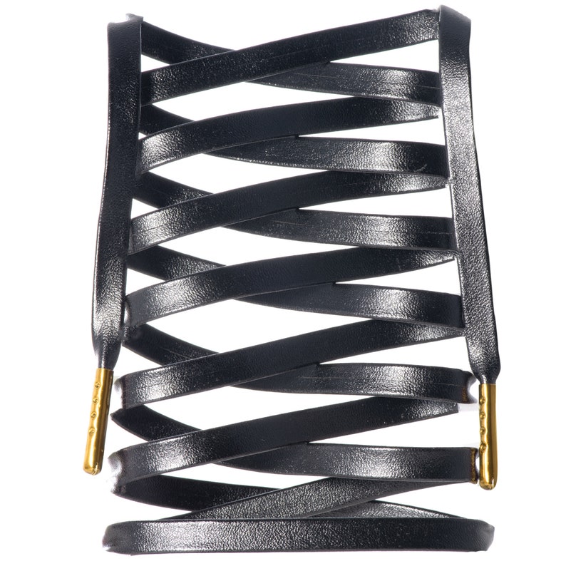 May include: Black leather shoelaces with gold metal tips, woven into a criss-cross pattern.