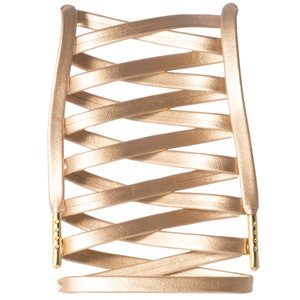 May include: A gold-colored leather bracelet with a woven design. The bracelet has a clasp on each end.