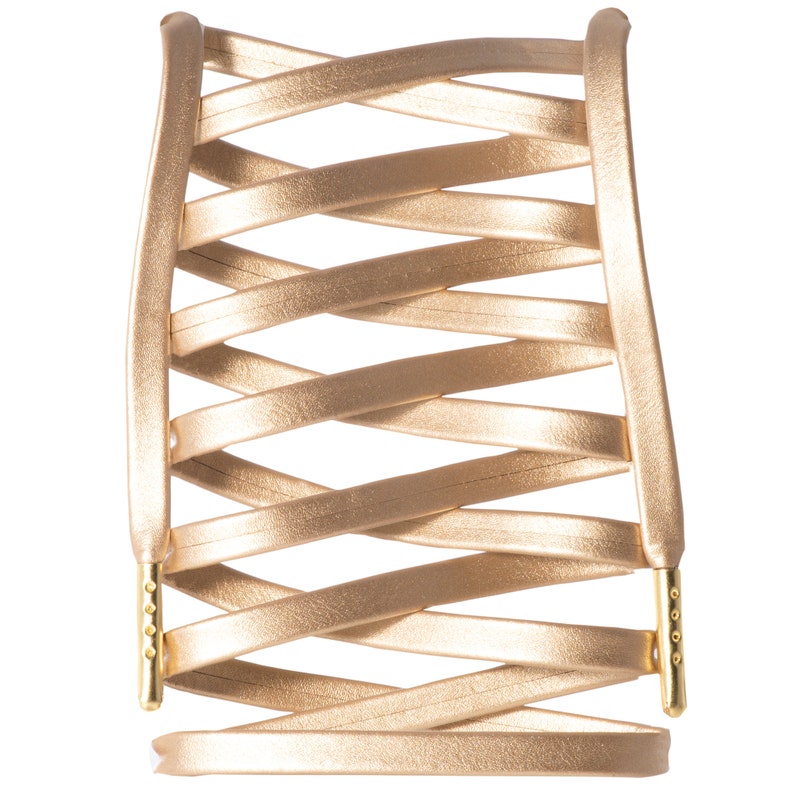 May include: A gold-colored leather bracelet with a woven design. The bracelet has a clasp on each end.