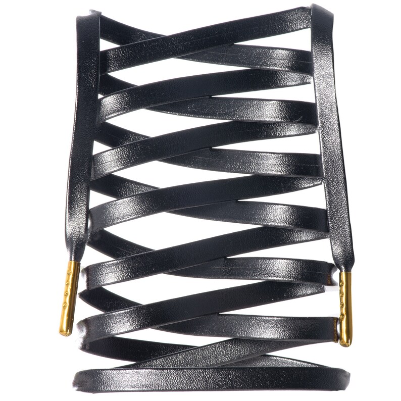 May include: Black leather shoelaces with gold metal tips, woven into a criss-cross pattern.