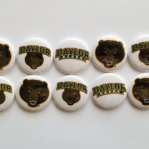 May include: A set of ten circular pin-back buttons featuring the Baylor Bears logo. Each button has a white background and displays either a graphic of a brown bear head or the green and gold text that reads Baylor or Baylor Bears.