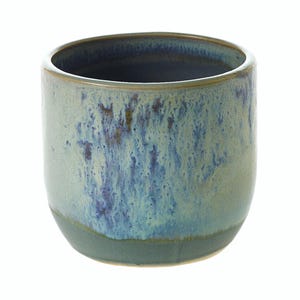 May include: A ceramic tumbler with a speckled glaze in shades of blue, green, and brown. The cylindrical cup has a dark blue interior and a rounded base. The exterior features a textured, mottled appearance.