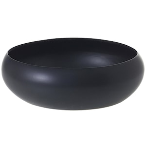 May include: A matte black, oval-shaped bowl. The bowl has a smooth, rounded design and a wide opening. The bowl is likely made of metal or a similar material. The bowl is empty and sits against a white background.