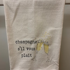 May include: White kitchen towel with the text "champagne s'il vous pla&icirc;t" and a drawing of two champagne glasses clinking.