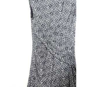 Puede incluir: Vestido sin mangas con un estampado geom&eacute;trico repetitivo en azul marino y blanco. La tela est&aacute; fruncida en la cintura, creando una silueta favorecedora. El vestido parece estar hecho de un material ligero, adecuado para el clima c&aacute;lido.