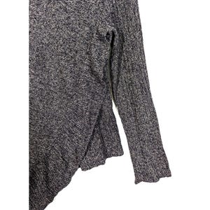 K&ouml;nnte beinhalten: Ein grau-wei&szlig; gesprenkelter Strickpullover mit Schlitzsaum und langen &Auml;rmeln. Die &Auml;rmel haben eine gerippte Textur. Der Pullover ist aus einem weichen, bequemen Material gefertigt.